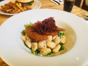 Schnitzel on top of creamy gnocchi and fresh greens at Mono in Glasgow