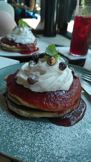 Lemon pancakes with strawberry jam, whipped cream, and roasted hazelnuts at Kafé Oransjeriet in Stavanger