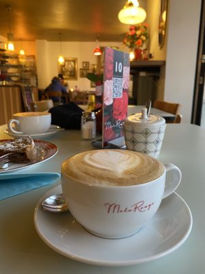 Veganer Soja-Cappuccino und links noch ein veganer Schoko-Apfel-Kuchen  at Molo Rouge in Wunsiedel