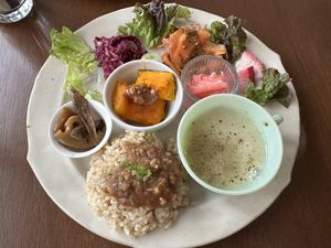 Lunch plate - cabbage with sesame seeds, carrot in basil sauce, pickled daikon, radish slices, potato soup, rice with soy based meat sauce, squash with peanut butter   at à petits pas in Sapporo