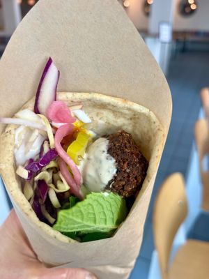 Falafel wrap with fresh made flatbread, herby falafel, tahini, coconut yogurt, pickled onions and loads of herbs.  at Ibiza in Santa Cruz