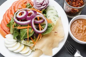 Vegan House Salad - A fresh garden salad of lettuce, cucumber, tomatoes, onion, served with a Thai peanut sauce and garnished with wonton chips.  Boiled egg added as an option.

 at Sukho Thai - Marigny in New Orleans