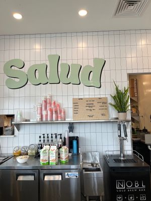 Salud sign behind the register with their coffee and tea menu at Salud in Portsmouth