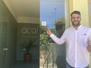 Yannis, hotel owner,  proudly showing Happycow sticker  at Acai Plant Based Hotel & Restaurant in Rhodes