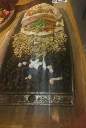 Vegan Chick’n Tacos (2): Signature tortillas filled with marinated vegan chick’n, charred tomato salsa, caramelized chipotle onions. Served with black beans & wild rice. at Nacho Daddy - Downtown in Las Vegas