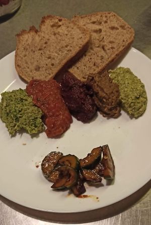 A mouth-watering selection of 5 freshly made plant-based dips with marinated cucumber and yummy sourdough bread from Nona's bakery. at Veganarchy in Antwerpen