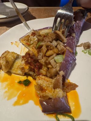 Cutting into the eggplant with duck  at Spicy Moon - Chelsea in New York City
