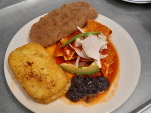 Chilaquiles rojos con milanesa de seitán y papa hashbrown. Queso de almendras y crema de avena. at 9 ó 6 Comida Vegana. in Puebla