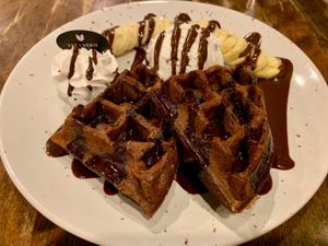 Chocolate flax seed waffles w/ coconut whipped cream, coconut ice cream, banana, and chocolate sauce   at Veganerie - Mercury Ville in Bangkok
