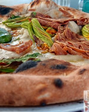 Fiori di zucca e Guanciale Vegana containing vegan mozzarella, pumpkin flowers, crispy vegan guanciale (a gluten-free, lentil-based vegan alternative), olive oil and basil. at Assaje - Navigli in Milan