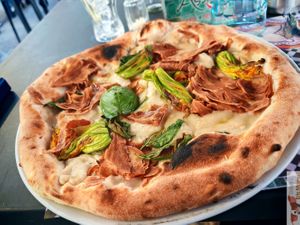 Fiori di zucca e Guanciale Vegana containing vegan mozzarella, pumpkin flowers, crispy vegan guanciale (a gluten-free, lentil-based vegan alternative), olive oil and basil. at Assaje - Navigli in Milan