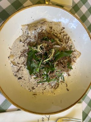 Rich, creamy vegan truffle ravioli topped with fresh herbs and shavings of truffle—an unforgettable dish that perfectly blends indulgent flavors and textures. at Teehaus im Englischen Garten Berlin in Berlin