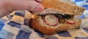 One delicious sandwich with vegan cream cheese, radish, olives, lettuce, and pickle 😋 at Namo Bakery in Warsaw