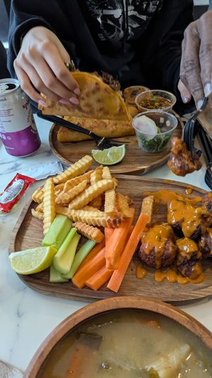 In front, cauliflower bites and fries plate. In back, gluten free birria tacos at PurelyPlant in Atlanta