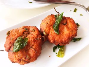 Tod Munn: Thai Un-fish cake, chickpeas, green beans, kefir lime leaves, curry paste, crispy basil with cucumber peanuts relish at Satdha Plant Based Thai Kitchen in Santa Monica
