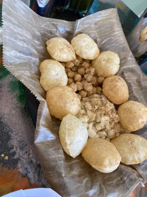 Forgot what this is but you make a hole, fill it, and add the tamarind and lime sauce. Delicious!  at Bombay Food Junkies in St Louis