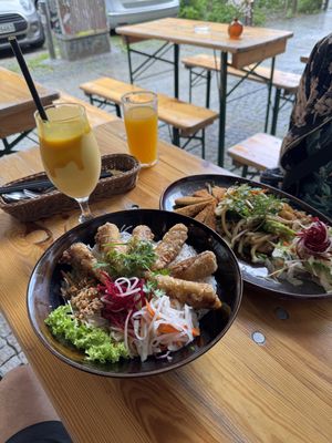 Crispy nems, udon noodles with fried mock chicken, and a mango lassi and juice.  at Dream Vegan in Berlin