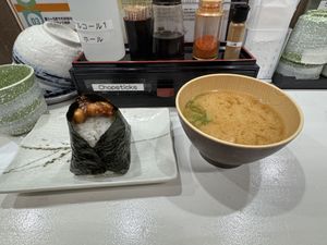 The two items I got, peanut miso onigiri on the left with some peanuts on top and tofu miso on the right. Water and cups available self serve along with chop sticks    at Onigiri Gorichan in Osaka
