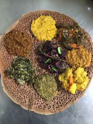 A combination of collard greens, yellow split peas, whole lentils, string beans, red split peas, and beets salad. Our Teff injera is sour fermented like flat bread with spongy texture made primely from teff ,an ancient grain native to Ethiopia.

 at Eat Today in St Louis