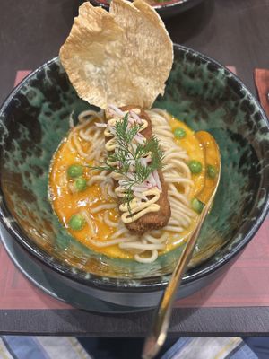 Panang curry with ramen noodles and a faux crab cake  at Vegan Pranakhon in Bangkok