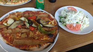Vegan Lahmachun topped with döner 'meat' and veggies, side salad at Dilgelay in Stuttgart