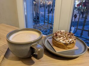 Cafe au lait with Cancan and view of Fontaine des Innocents out window #Veganuary at Land & Monkeys - Les Halles in Paris