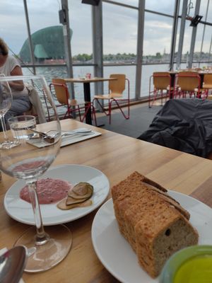 Appetizes with view of Nemo: fesh berries from local food Forrest, bay leaf oil and GF bread at TestTafel in Amsterdam