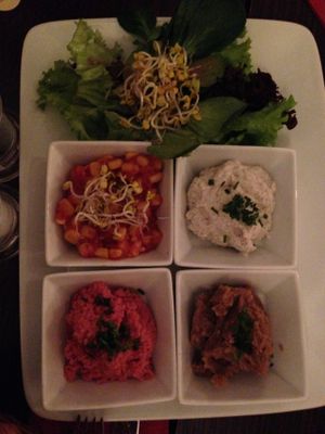 Starters plate - beetroot hummus, chestnut paste, truffle spread, corn salsa, salad, bread basket at Bodhi in Munich