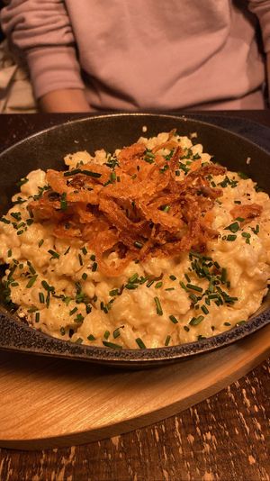 Käsespätzle: tiny noodles smothered in creamy cheesy sauce, served with caramelized onions and chives, as well as a side salad. Very authentic   at Bodhi in Munich