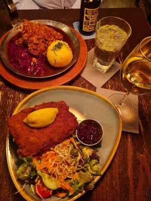 Crispy steak with potato, cabbage, apple & beer gravy (top) and Vienna style schnitzel with potato salad and lingonberry jam. at Bodhi in Munich