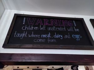 On the chalkboard today: "Warning! Children left unattended will be taught where meat, dairy, and eggs come from." at Bodhi in Munich