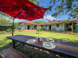 Table under the trees and view at the corridors of the historic house. at Finca San Pedro in Barichara