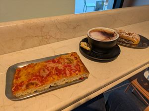 Pizza slice, hot chocolate, pastry at The Sanctuary - Potsdamer Platz in Berlin