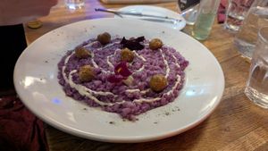 Risotto al cavolo cappuccio viola: Eye Catching purple risotto rice made with purple cabb served with parmesan fondue and pan-fried sausage at Sora Diana in Edinburgh