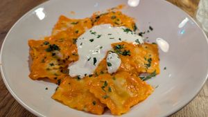 Ravioli Nduja e Stracciatella:  Fresh ravioli stuffed with Nduja and creamy cheese served with a smooth sweet red pepper sauce topped with a fresh dollop of stracciatella chees at Sora Diana in Edinburgh