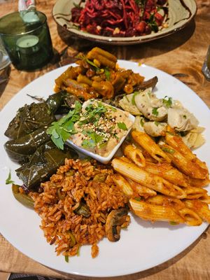 Antipasti: gefüllte Weinblätter,  Mediterraner Reis mit Oliven, Rote Pesto Pasta, Artischockenherzen, Geschmorte grüne Bohnen,gegrillte Zucchini mit Thymian; in der Mitte: Hummu at Vengo Die Gemusekuche in Bremen