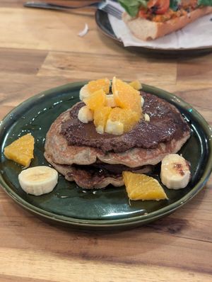 Pancakes with chocolate sauce, banana and orange at fronda cafe  in Valencia