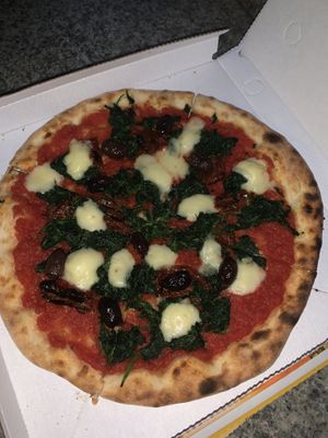 Vegan pizza with spinach sundries tomatoes and cheese at Pizzeria L'Angelo in Venice