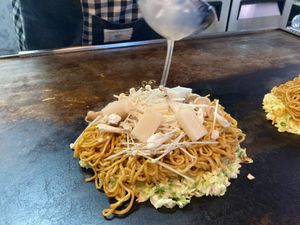 Step2 Pour the stock over the stir-fried vegetables, soba, and batter and adjust the flavor. at Okonomiyaki FUJI in Takehara