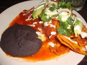 CHILAQUILES
Tortilla chips simmered in a spicy tomato salsa, topped with cashew crema, cilantro and avocado, served with black beans at Gracias Madre - WeHo in West Hollywood