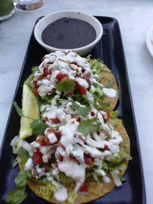 COCONUT CEVICHE TOSTADAS - two tostadas, black beans, coconut ceviche, guacamole, lettuce, cashew creme, cilantro, side of black beans at Gracias Madre - WeHo in West Hollywood