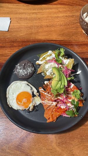 chilaquiles divorciados con queso, crema , huevo y aguacate. opción vegana con crema de Nuez de la india y setas al ajillo. at Pook in Playa Del Carmen