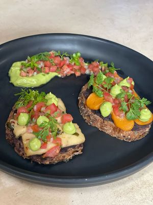 Molletes with homemade Plant based Cheese (Cheddar & Pepper Jack) served with refried beans, pico de gallo and Guacamole. at Pook in Playa Del Carmen