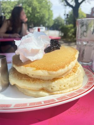 Heavenly fluffy pancakes with blueberry compote between layers, whipped cream & maple syrup  at Mamalicious in Hamburg