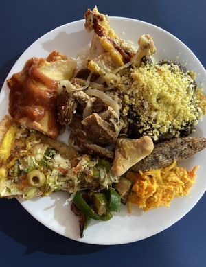 Open buffet plate: Pizza, pancake, cauliflower, rice and beans (feijoado), kibe, beef with onions, carrot salad, peppers and fried salgadinhos  at LAR vegan in Sao Paulo