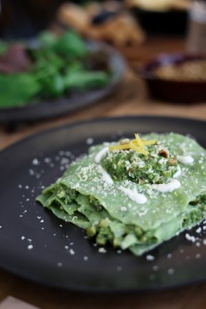 Open spinach ravioli with walnut pesto and cashew parmesan at Kaiaroha Vegan Deli and Eatery in Auckland