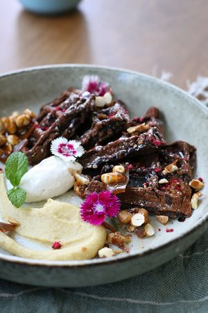 Snickers style Chocolate Kumara Waffles. Glutenfree chocolate waffles with cashew date caramelle, peanut brittle and coconut whipped cream and a rich chocolate sauce. at Kaiaroha Vegan Deli and Eatery in Auckland