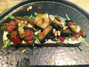 Zuurdesembroodje met hoemoes, gegrilde paprika/aubergine, rucola en pijnboompitten. at Trankilo in Heemstede