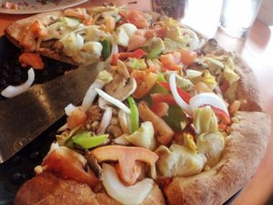 Medium "Grateful Veg" pizza with artichoke hearts instead of olives, wheat crust, non-raw tomatoes at Woodstock's Pizza - Pacific Beach in San Diego