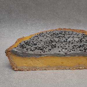Mango/black sesame pie with a balanced sweetness. It has a hard crust, a pudding-like mango layer and a creamy sesame top. at KLUTS in Utrecht